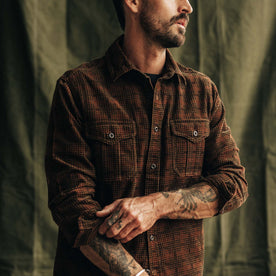 fit model adjusting the sleeves on The Saddler Shirt in Dark Roast Plaid Cord, Wovens by Taylor Stitch