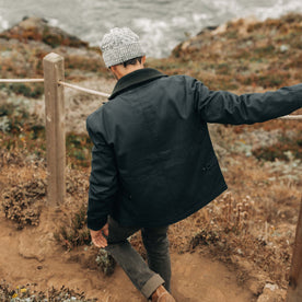 fit model walking down the coast in The Deck Jacket in Dark Navy Dry Wax, Outerwear by Taylor Stitch