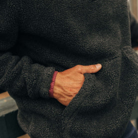 fit model with his hands in the pocket of The Nomad Pullover in Charcoal Heather Sherpa, Knits by Taylor Stitch