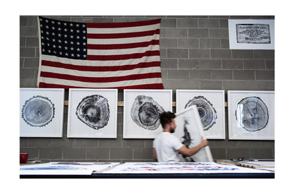 Jack Ludlam examinging multiple prints of woodcuts