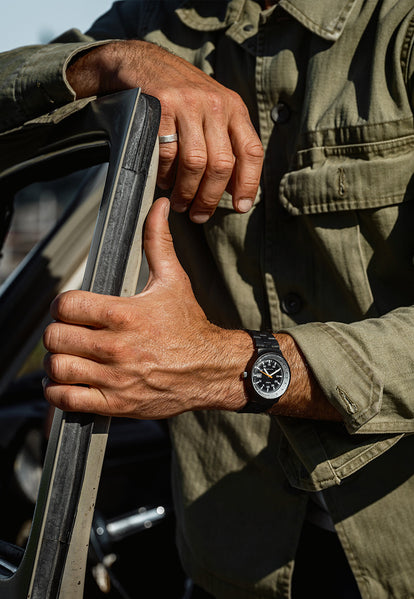 Model standing by a car in the 1978 Timex Black Max