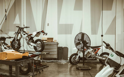 Several bikes under construction, on thw rokshop floor and up on workbenches.