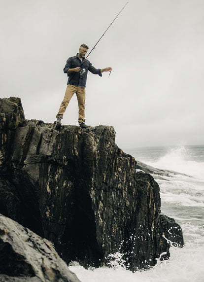 Model holding a fishing rod in The Shop Shirt in Navy Chipped Canvas