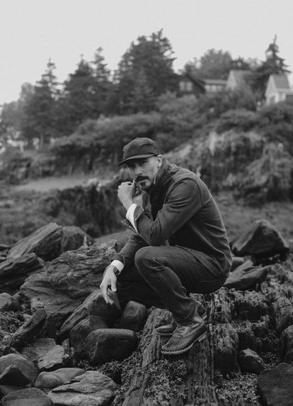 Model sitting on rocks in Chipped Canvas workwear