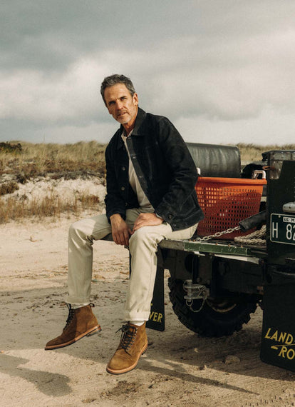 Model wearing The Ryder Jacket, sitting on the back of a jeep