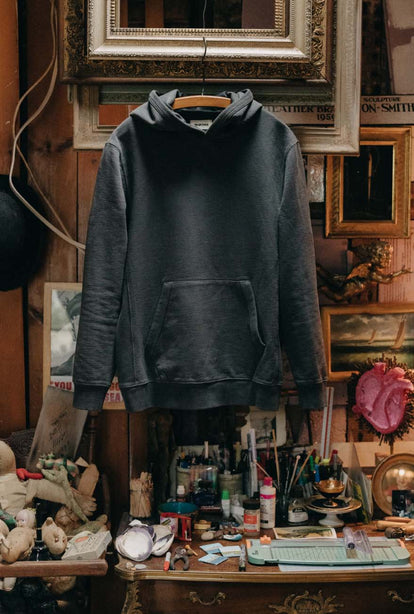 The Cotton Hemp Hoodie in Asphalt hanging in an art studio