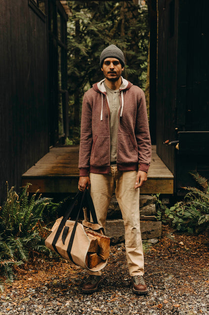 Model wearing The Après Zip Hoodie by a cabin in the woods