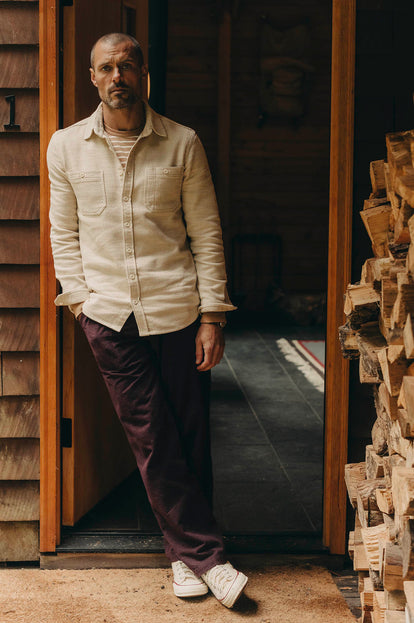 Model standing in a doorway in The Utility Shirt in Natural Sashiko and The Breakwater Pant in Nutmeg Donegal