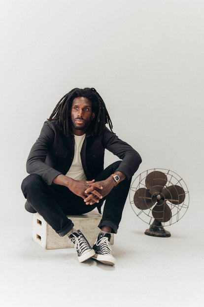 Model sitting in The Maritime Shirt Jacket in Faded Black Moleskin Twill