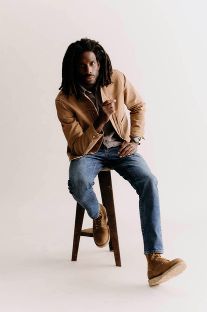 Model sitting on a stool in The Ryder Jacket and Ledge Shirt in Granite Linen Tweed