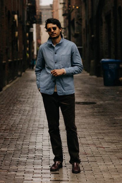 Model wearing The Ojai Jacket in French Blue Herringbone, standing in an alley