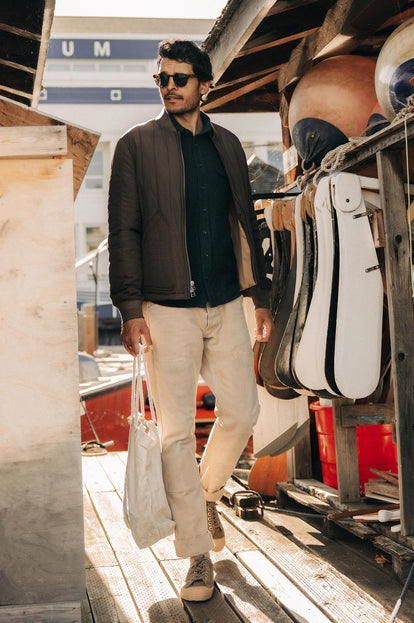 Model walking on the dock in The Able Jacket in Soil Quilted Nylon