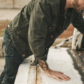 The fit model leaning into his truck, Outerwear by Taylor Stitch