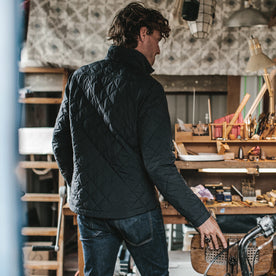 The fit model wearing the vertical jacket in his art shop, Outerwear by Taylor Stitch