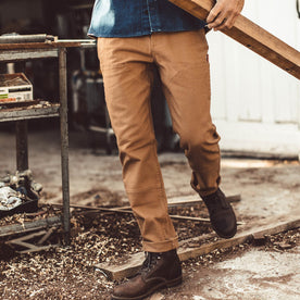 The fit model working in his chore pants in his garage, Pants by Taylor Stitch