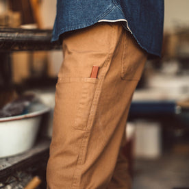 Fit model in the chore pants in washed camel, Pants by Taylor Stitch