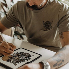 fit model sketching on his tablet in The Heavy Bag Tee in Sage Dahlia, Knits by Taylor Stitch