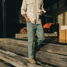 fit model wearing The Chore Pant in Ocean Boss Duck on the steps of a house, Bottoms by Taylor Stitch