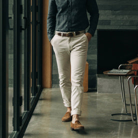 fit model wearing The Slim Foundation Pant in Organic Stone with a shirt tucked in, Bottoms by Taylor Stitch