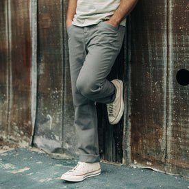 fit model leaning against the wall in The Camp Pant in Gravel Boss Duck, Bottoms by Taylor Stitch