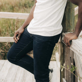 fit model leaning against the wall wearing The Demcratic Jean in Wallace Wash Organic Selvage, Bottoms by Taylor Stitch