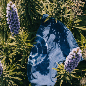 outdoor material shot of The Botanical Dye Tee in Indigo, in bed of plants, Knits by Taylor Stitch