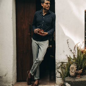 fit model wearing The Easy Pant in Navy Herringbone, drinking coffee, Bottoms by Taylor Stitch