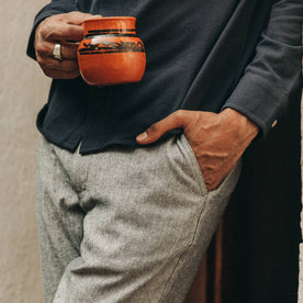 fit model wearing The Easy Pant in Navy Herringbone, hand in pocket, holding mug, Bottoms by Taylor Stitch