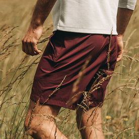 fit model wearing The Traverse Short in Wine, side profile in field, Shorts by Taylor Stitch