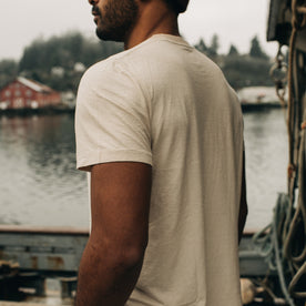 fit model walking on a boat in The Cotton Hemp Tee in Sand, Knits by Taylor Stitch