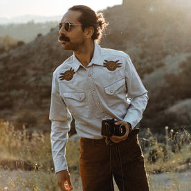 fit model holding a camera in The Embroidered Western Shirt in Washed Selvage, Wovens by Taylor Stitch