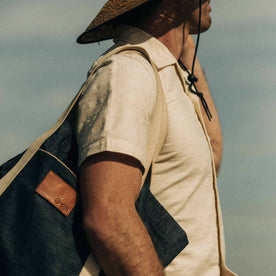 fit model wearing The Short Sleeve Hawthorne in Sand while holding a tote bag, Wovens by Taylor Stitch