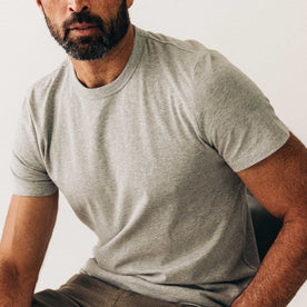 fit model sitting wearing The Organic Cotton Tee in Heather Grey, Knits by Taylor Stitch