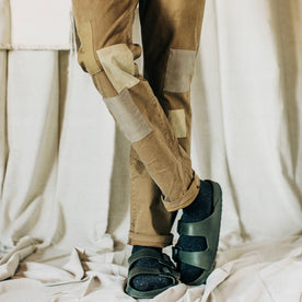 material shot of The Atelier and Repairs Chino in British Khaki, legs crossed on model, Bottoms by Taylor Stitch