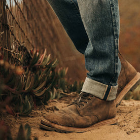 fit model wearing The Democratic Jean in in 18 Month Wash Organic Selvage, cuffed with boots, Bottoms by Taylor Stitch