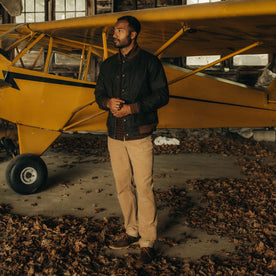 fit model in front of a plane in The Bomber Jacket in Bark EverWax, Outerwear by Taylor Stitch