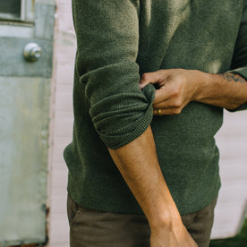 fit model showing off the sleeves on The Hudson Sweater in Heather Green, Knits by Taylor Stitch