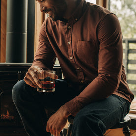 fit model sitting in The Jack in Chestnut Oxford, Wovens by Taylor Stitch