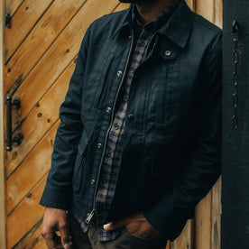 fit model leaning against the wall wearing The Pathfinder Jacket in Navy Dry Wax, Outerwear by Taylor Stitch