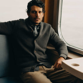 fit model sitting in The Crawford Sweater in Charcoal, Knits by Taylor Stitch