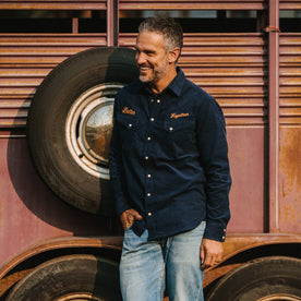 fit model wearing The Western Shirt in Better Together leaning up against a tire, Wovens by Taylor Stitch