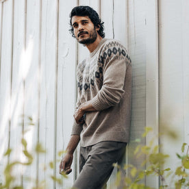 fit model leaning against the wall posing in The Magnus Sweater in Natural, Knits by Taylor Stitch