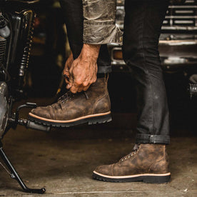 fit model tying the shoelace of The Moto Boot in Espresso Grizzly, Footwear by Taylor Stitch