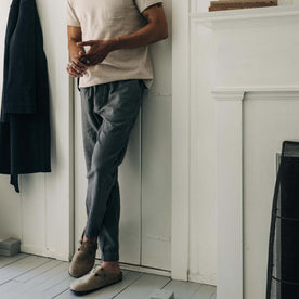 fit model leaning against the wall wearing The Apres Pant in Heather Grey Double Cloth, Bottoms by Taylor Stitch