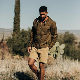 our fit model wearing The Welterweight Winslow in Field Tan Waxed Canvas out in the desert—walking shot, Outerwear by Taylor Stitch