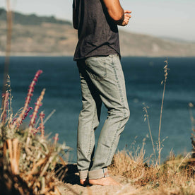 our fit model wearing The Slim Jean in 24-Month Wash Japanese Selvage—facing ocean, Denim by Taylor Stitch