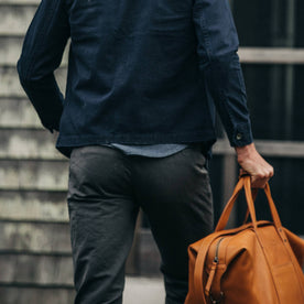 fit model wearing The Morse Pant in Charcoal Slub Linen, back shot holding bag, Bottoms by Taylor Stitch