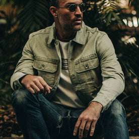 fit model wearing The HBT Jacket in Washed Olive, sitting down, Outerwear by Taylor Stitch