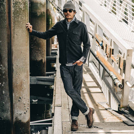 our fit model wearing The Slim Everyday Jean—standing on a dock looking ahead, Bottoms by Taylor Stitch