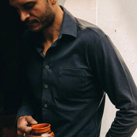 fit model wearing The California in Navy Pique, holding mug, looking down, Knits by Taylor Stitch